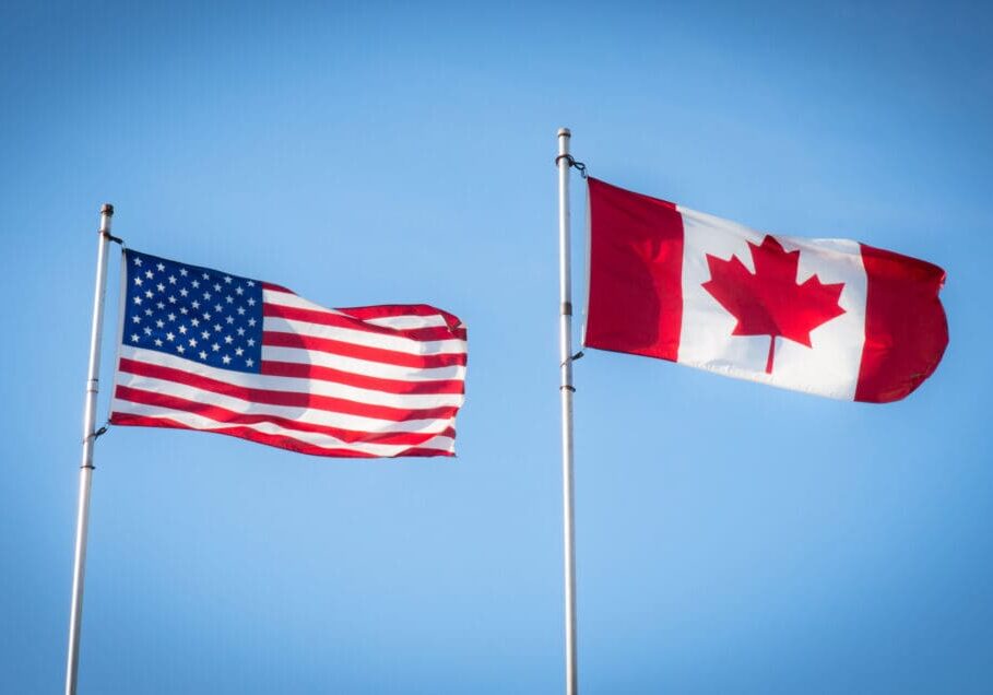 The Canadian and American flags fly together.